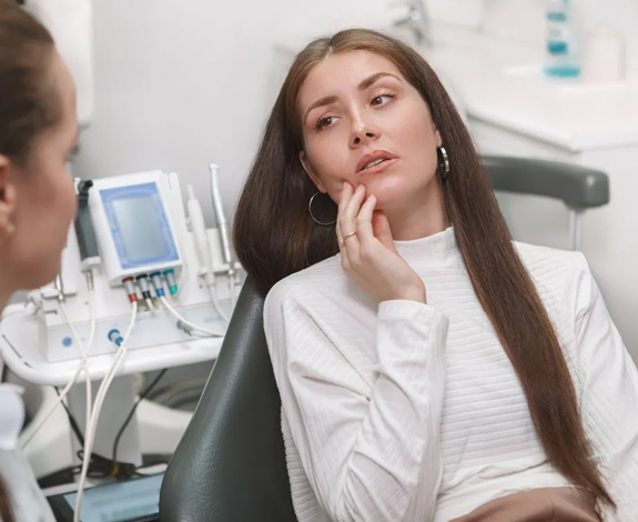 Young woman in dental chair with orthodontist during consultation in modern dental office.